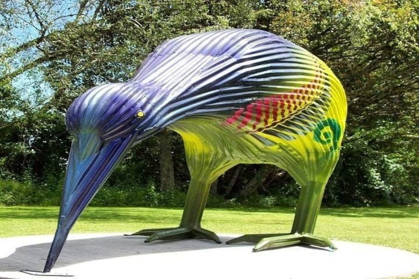A colorful sculpture of a bird in a park. 5