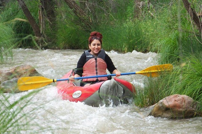Une personne fait du kayak sur une rivière, entourée de rochers et de verdure. 3