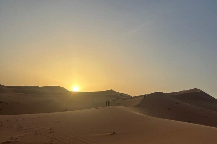 Un paysage désertique avec des dunes de sable et un soleil couchant. 5