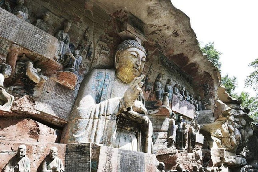 A large Buddha statue with multiple smaller statues carved into the rock face. 5