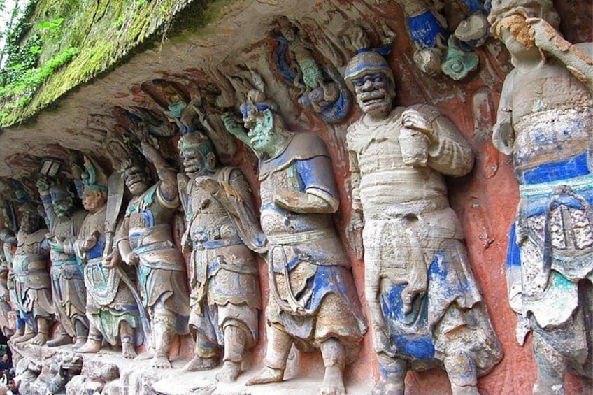 A row of stone statues with blue and white painted details, set against a red background. 4