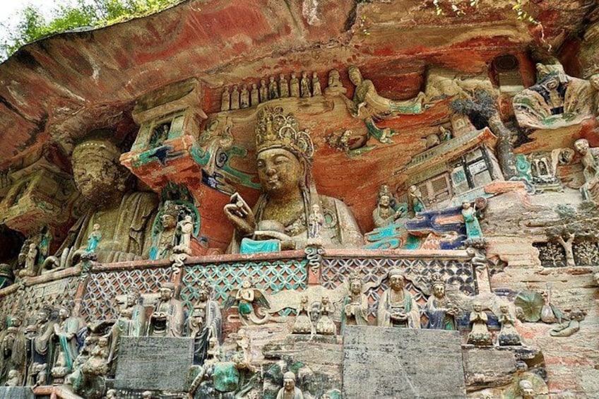 A large rock face with intricate carvings of figures and scenes, likely of religious or historical significance. 3