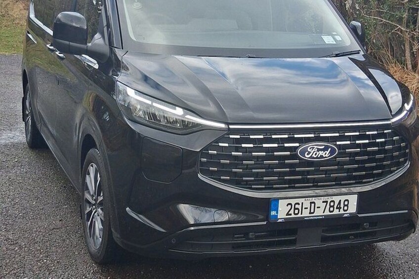 Un SUV Ford negro estacionado en una calle mojada. 3