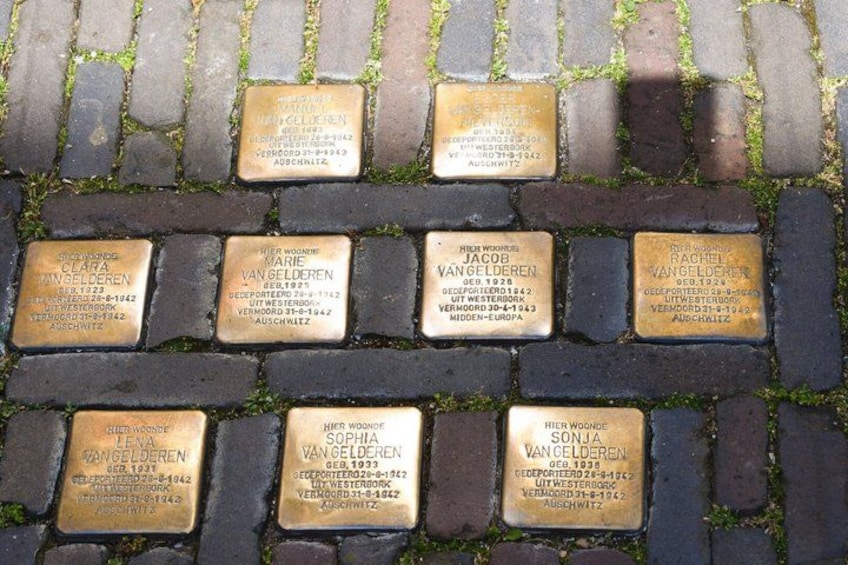 A series of engraved plaques on a brick pavement, each commemorating individuals with their names and dates of birth and death. 4