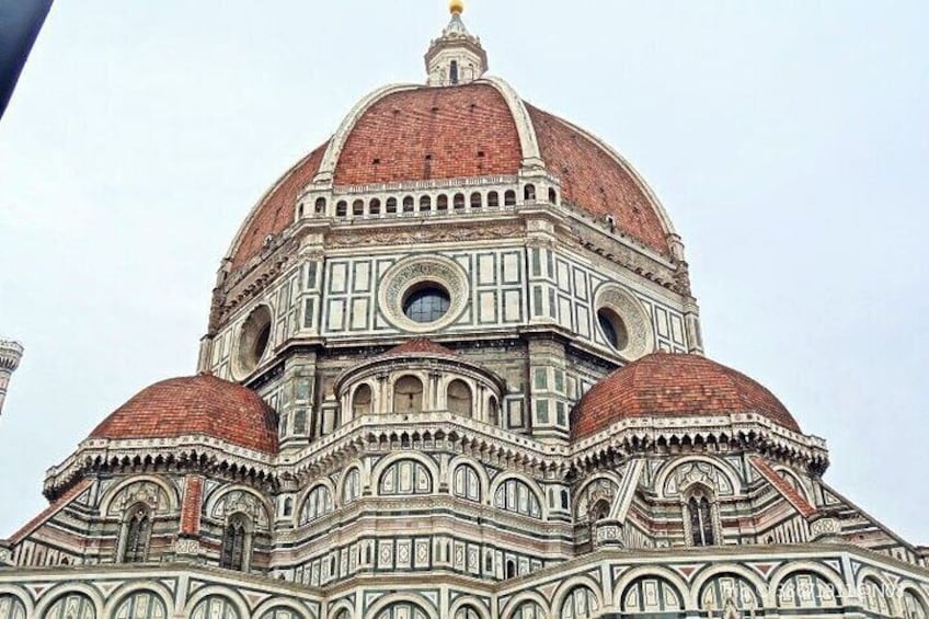 The facade of the Florence Cathedral with its distinctive red-tiled dome and intricate white and green marble patterns. 2