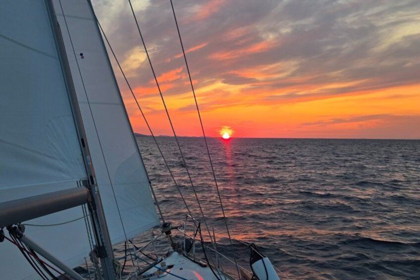 A sailboat with a sunset in the background. 1