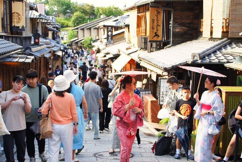 Een drukke straat in een traditioneel Japans stadje, met houten gebouwen en mensen die lopen. 2