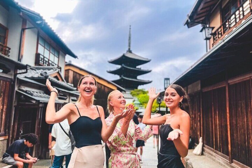 Een traditionele Japanse straat met houten gebouwen en een pagode op de achtergrond. 2