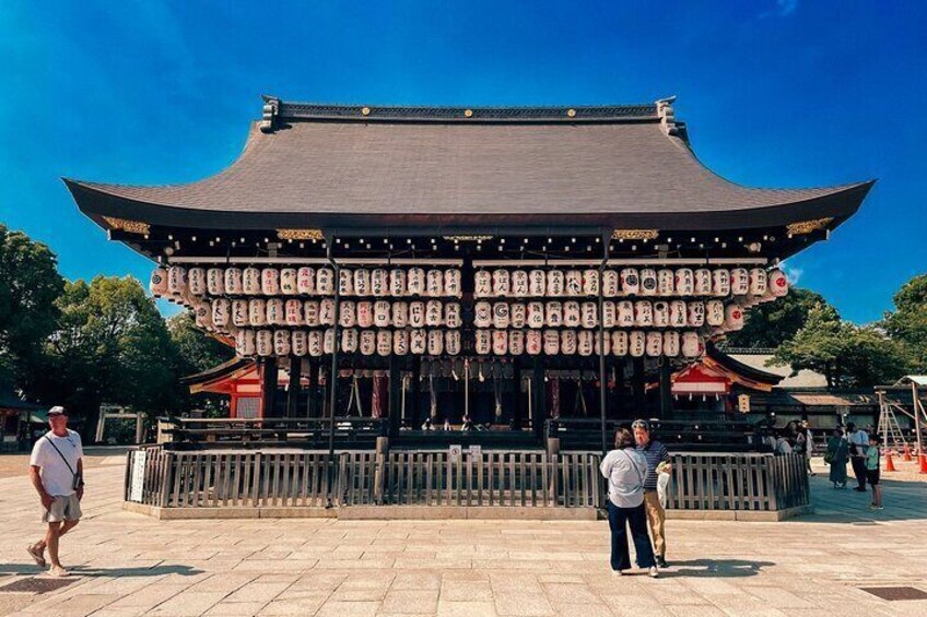 Een traditioneel Japans gebouw met een gebogen dak en een houten hek ervoor. 3