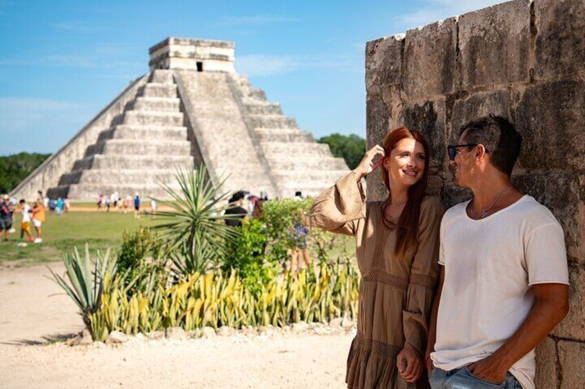 Ein Paar steht vor einer großen Pyramide, im Hintergrund sind Touristen zu sehen. 5