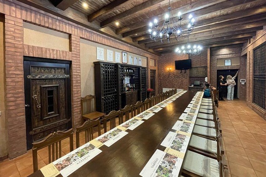 A long wooden table with menus, a brick wall, a chandelier, and a television. 5