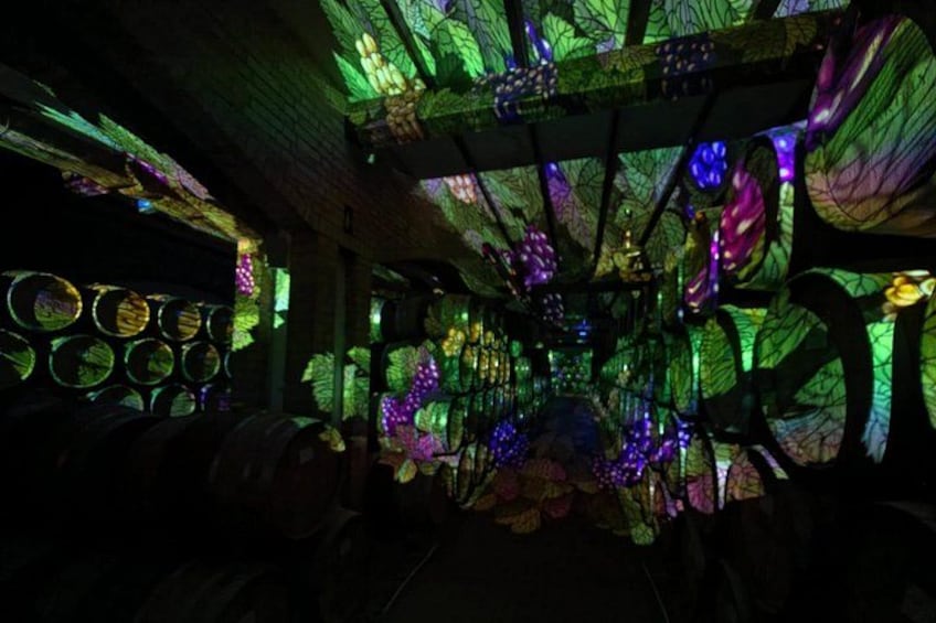 A dimly lit room with a ceiling adorned with colorful, illuminated leaves and circular patterns. 4