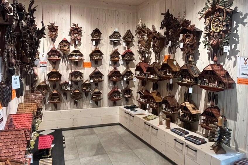A shop with various wooden cuckoo clocks on display. 3