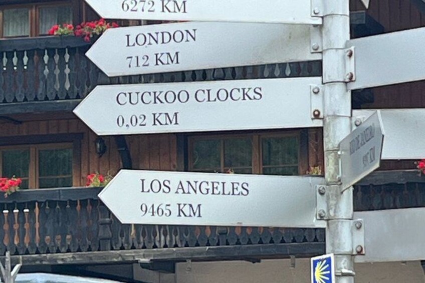 A directional signpost with distances to London, Los Angeles, and Cuckoo Clocks. 4
