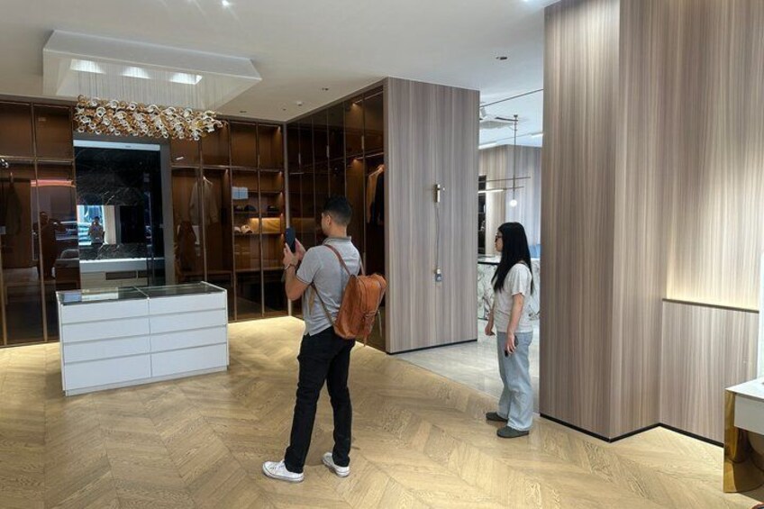 Un intérieur moderne avec un plancher en bois, une vitrine et une personne utilisant un smartphone. 4