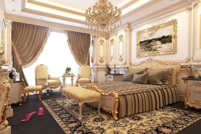 Un dormitorio lujoso con muebles ornamentados, una cama grande y una araña. 5