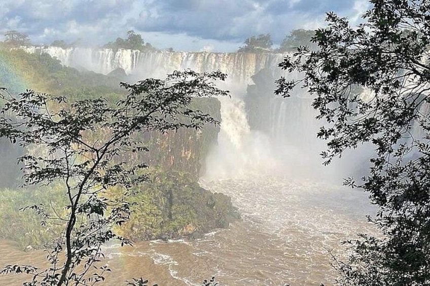 Una cascada con bruma, rodeada de árboles y un río. 2