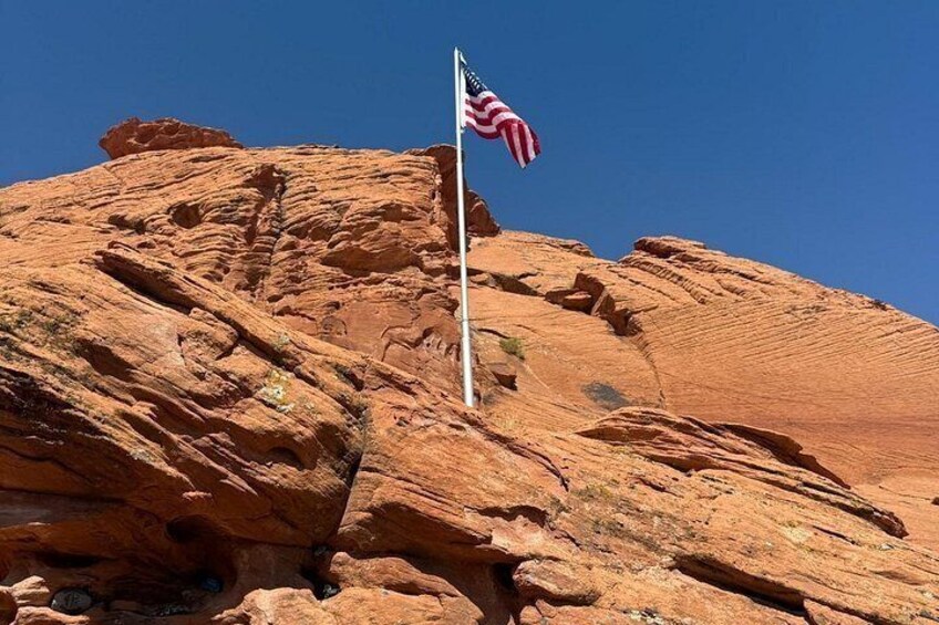 Eine rote Felsformation mit einer amerikanischen Flagge auf einem Fahnenmast. 2