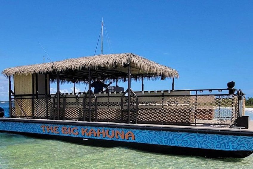 Een boot genaamd 'The Big Kahuna' met een rieten dak en een blauw patroongedecoreerde romp. 1