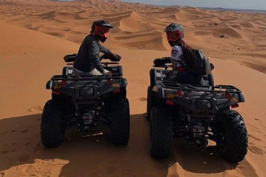 Two people on ATVs in a desert with sand dunes. 5