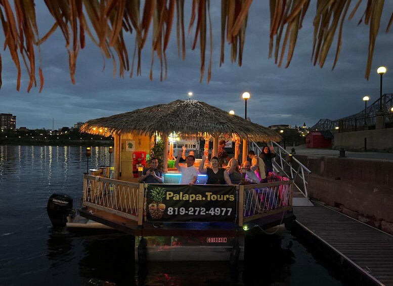 Un bote con techo de paja y un cartel publicitario de 'Palapa Tours' con un número de teléfono. 2
