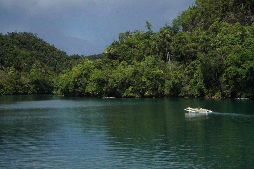 A boat on a calm lake surrounded by dense forest. 5