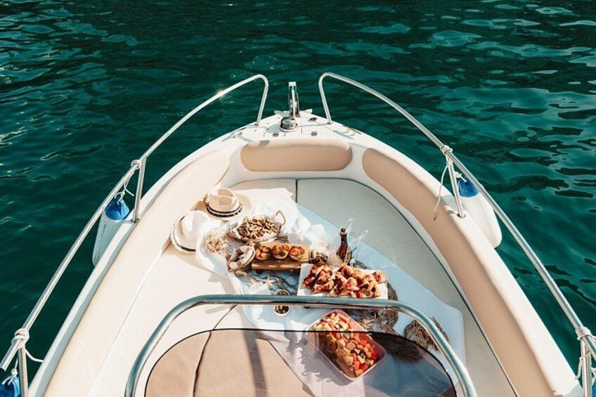 Un bateau avec un espace repas aménagé sur le pont, comprenant des assiettes de nourriture et une tasse. 3