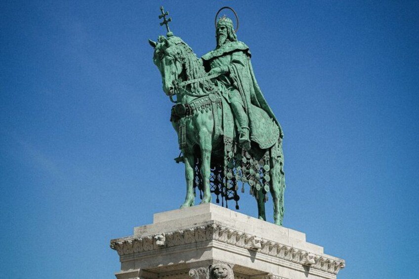 A statue of a man on horseback, mounted on a pedestal, with a clear blue sky in the background. 5
