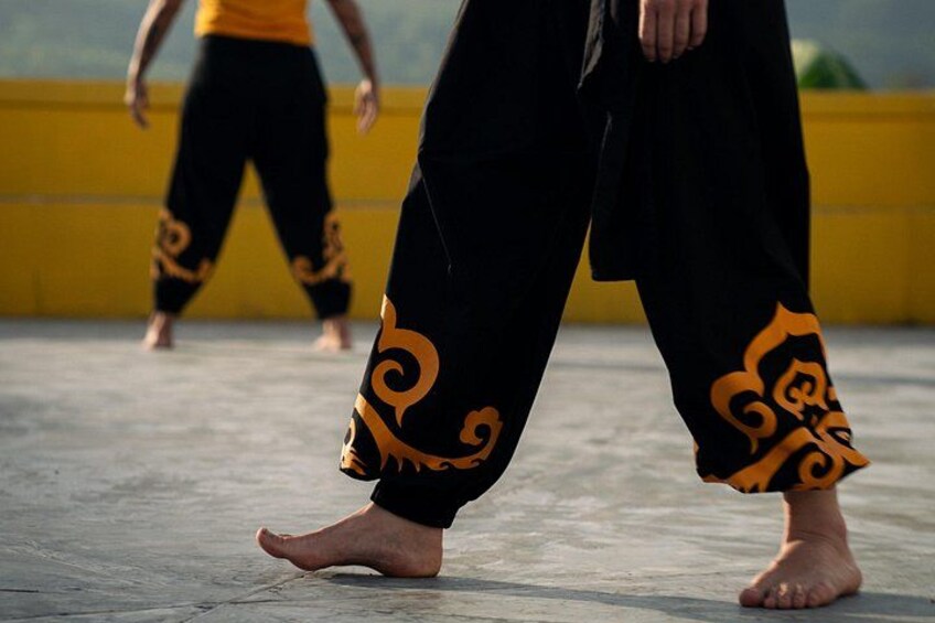 A person walking on a concrete surface with a yellow wall in the background. 3