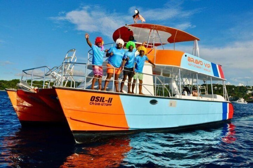A colorful boat with people on board, a clear sky, and water. 1