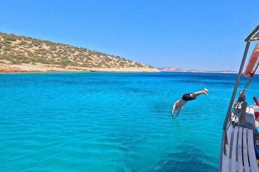 A person diving into clear blue water from a boat. 5