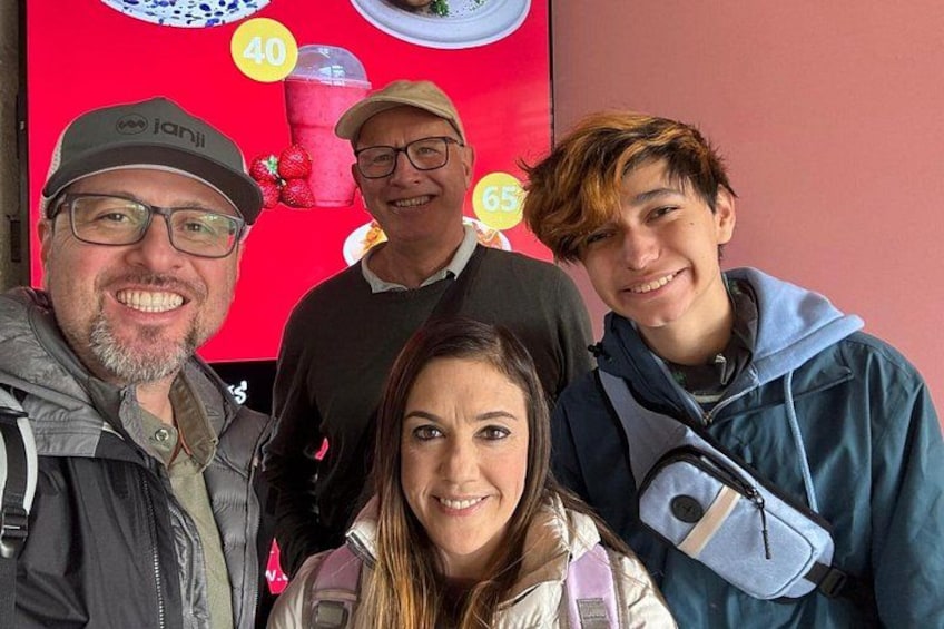 A group of people in front of a red wall with a yellow circle and a number '40' on it. 3