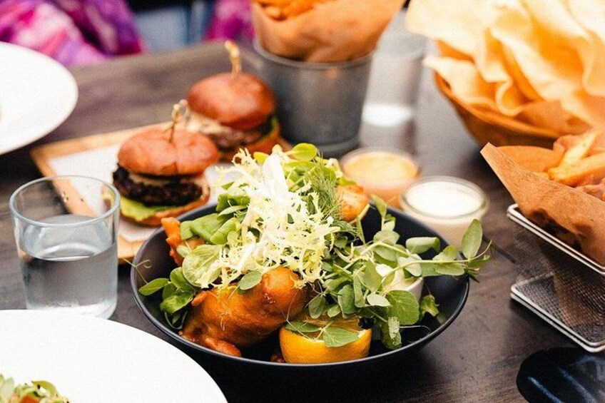 A meal with a burger, salad, and a drink. 2
