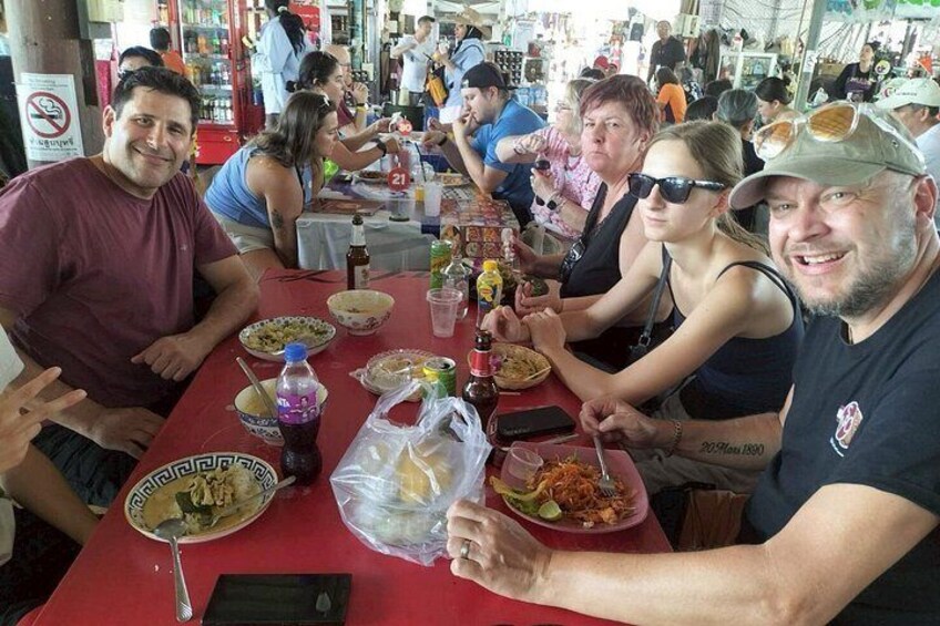 A group of people sitting at a table with food and drinks. 4