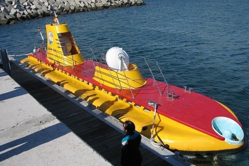 Un sous-marin jaune et rouge était amarré à un quai. 2
