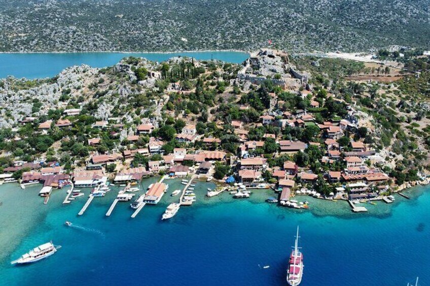 Une vue aérienne d’un village côtier, avec ses maisons, ses bateaux et une mer bleue et limpide. 5