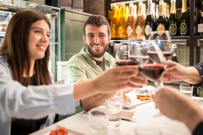 A group of people toasting with wine glasses at a restaurant. 4