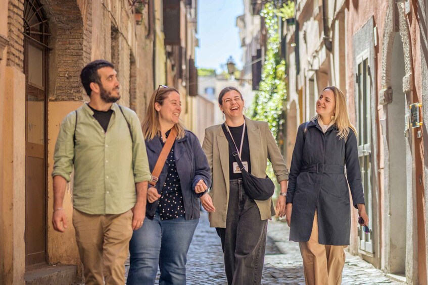 A group of four people walking down a cobblestone street in a historic town. 2