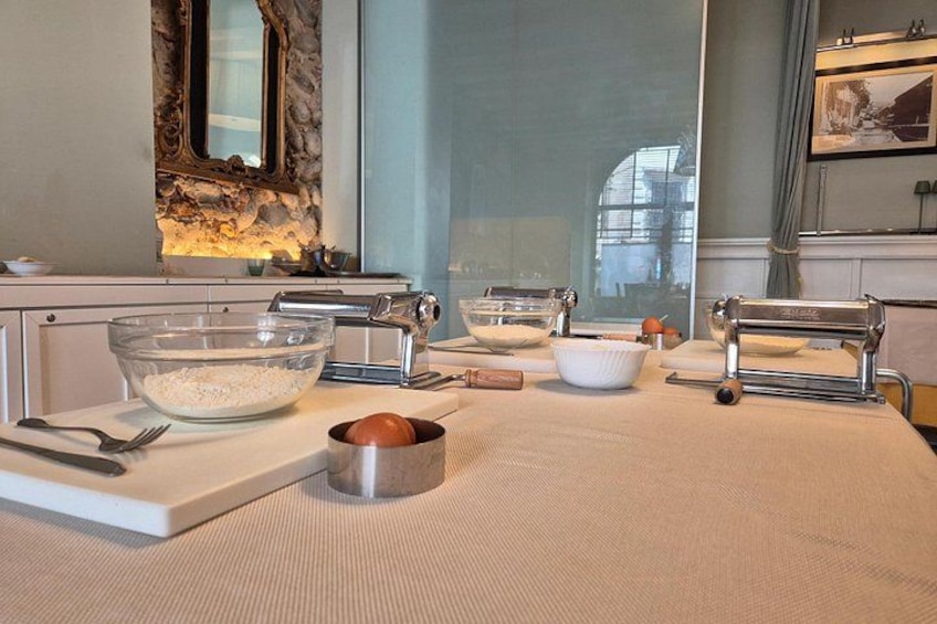 A kitchen with a stone wall, a large window, and various cooking utensils on the counter. 2
