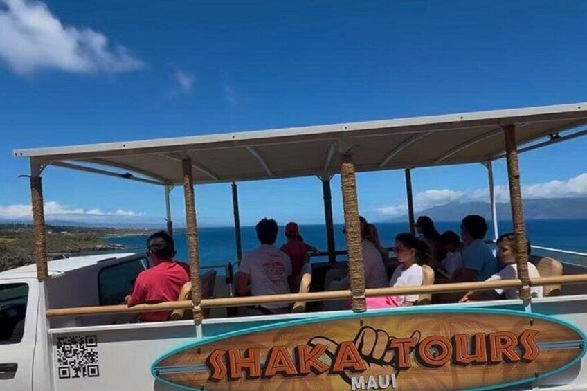 Un grupo de personas en un bote con un cartel que dice 'Shaka Tours Maui'. 2