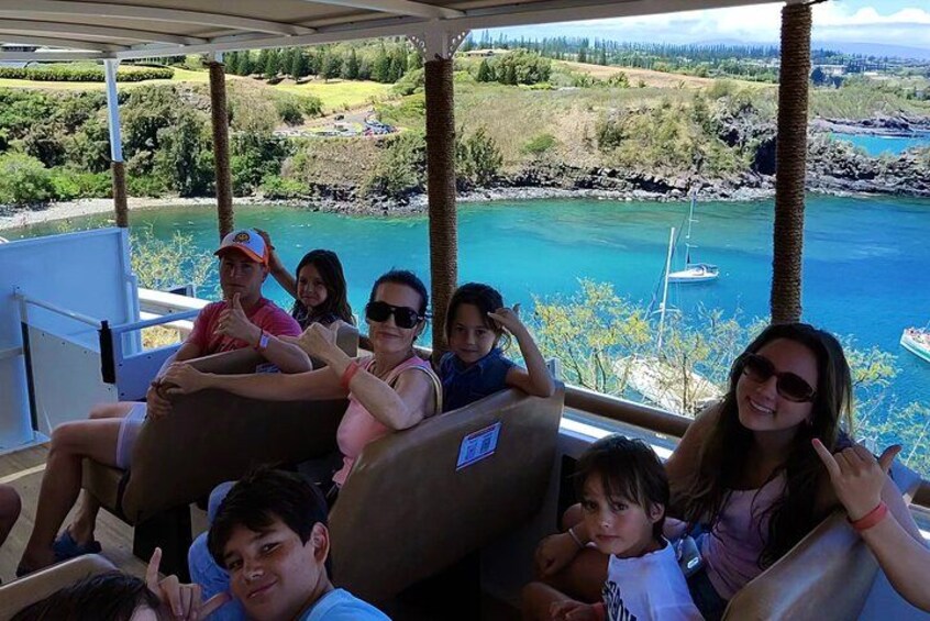 Een groep mensen op een boot, met een prachtig uitzicht op een meer en bergen. 5