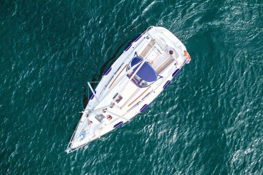 Un yacht blanc à la coque rayée de bleu et de blanc navigue sur une étendue d’eau. 2