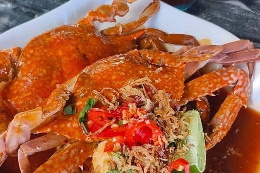 A crab dish with red chili and green herbs. 4