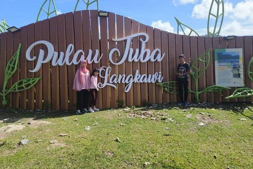 A wooden fence with the text 'Pulau Tuba Langkawi' and a signboard. 3