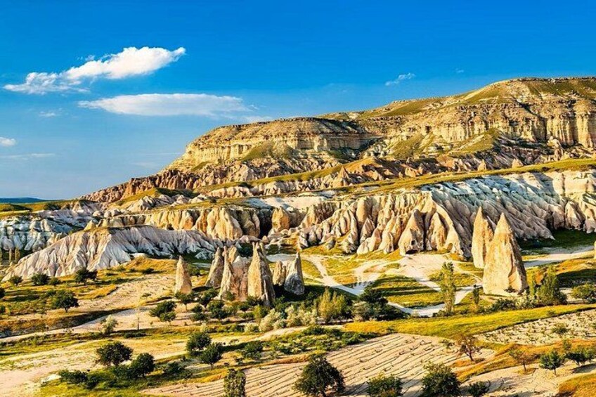 A landscape with distinctive rock formations, a river, and a hill in the background. 5