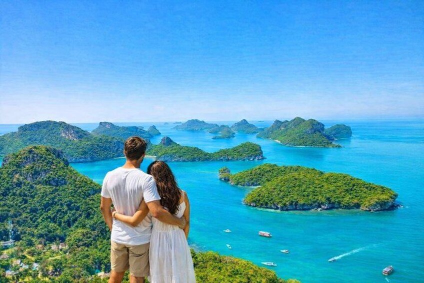 Una pareja contemplando un mar turquesa con varias islas pequeñas. 1