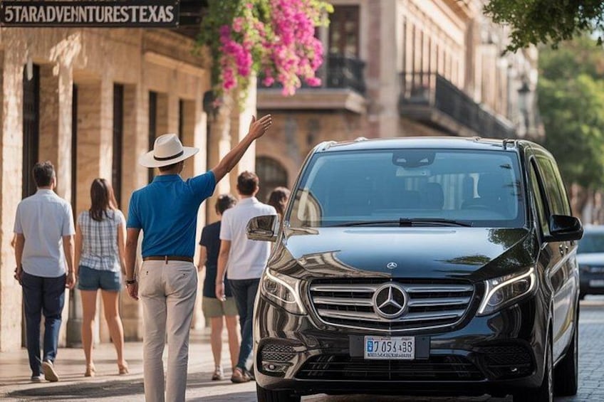 Een zwarte Mercedes-Benz SUV staat geparkeerd op een stadsstraat, voorbijgangers lopen langs. 1