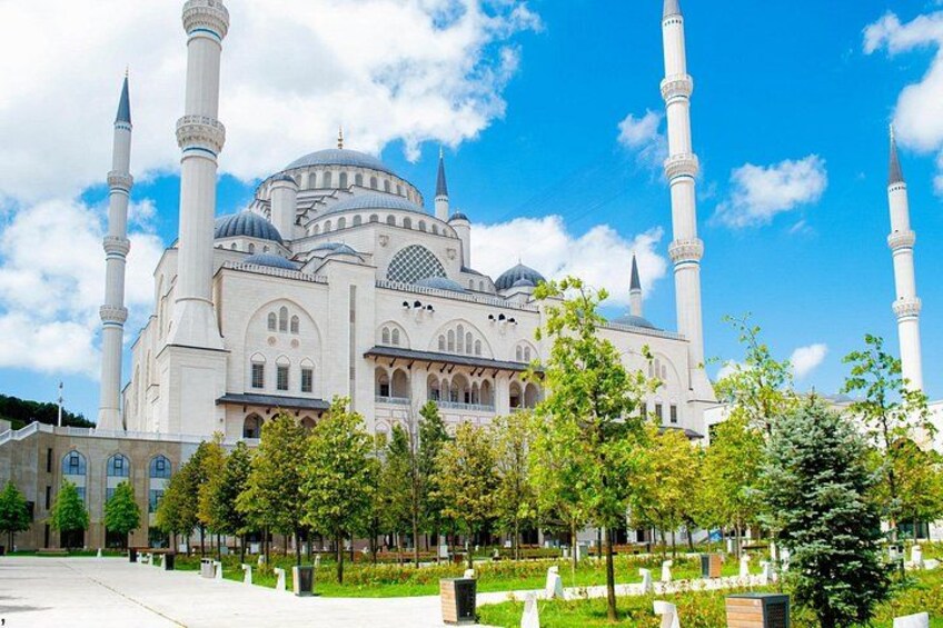 Une grande mosquée dotée de plusieurs minarets, entourée d’un jardin bien entretenu, agrémenté d’arbres et de sentiers. 5