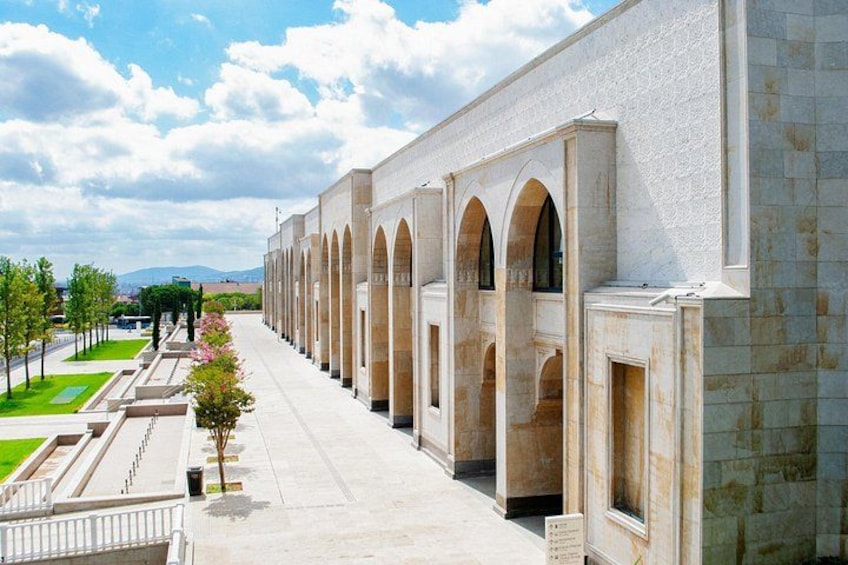 Un long bâtiment doté de fenêtres en arc de cercle et d’un trottoir dallé. 2