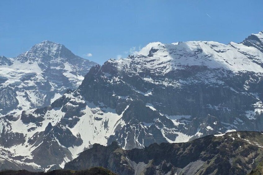 A snow-covered mountain range with sharp peaks and rugged terrain. 3